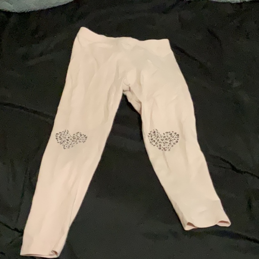 Little girl, pink leggings with cheetah print hearts on the knees